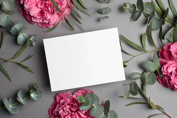 Bruiloft uitnodiging of wenskaart mockup met eucalyptus en roze pioenroos bloemen. — Stockfoto