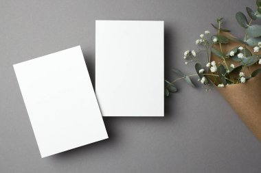 Fotokopi alanı, ön ve arka tarafları, okaliptüs ve çikila çiçekleri olan düğün davetiyesi modeli..
