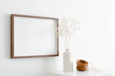 Resim, fotoğraf ya da baskı sunumu için fotokopi alanı olan yatay ahşap çerçeve modeli. Mobilyalı beyaz duvar ve minimalist iç dizaynlı kuru çigila fabrikası.