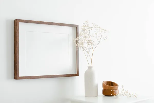 Resim, fotoğraf ya da baskı sunumu için fotokopi alanı olan yatay ahşap çerçeve modeli. Mobilyalı beyaz duvar ve minimalist iç dizaynlı kuru çigila fabrikası.
