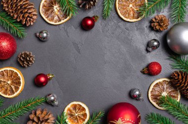 Noel dairesi kuru portakallar, koniler ve toplar koyu grunge arka planda yatıyordu.