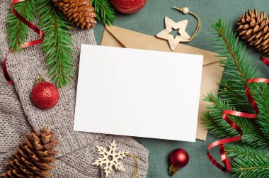 Noel ya da Yeni Yıl tebrik kartı modeli zarflı ve köknar ağacı dallarıyla süslenmiş.