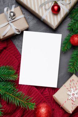 Noel ya da Yeni Yıl tebrik kartı modeliyle süslenmiş hediye kutuları ve kırmızı örülmüş köknar ağacı dalları