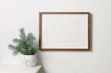 Resim, fotoğraf ya da baskı sunumu için kopya alanı olan çerçeve modeli. Noel ağacı olan beyaz bir duvar. Asgari biçim iç mimarisi.
