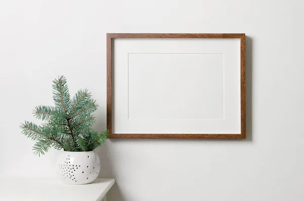 Resim, fotoğraf ya da baskı sunumu için kopya alanı olan çerçeve modeli. Noel ağacı olan beyaz bir duvar. Asgari biçim iç mimarisi.