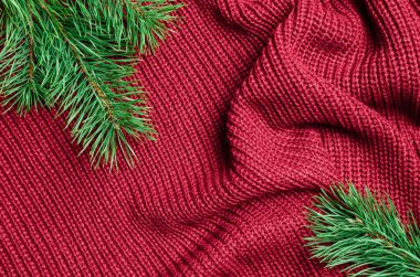 Yeşil çam ağacı dallarıyla kırmızı örülmüş Noel arkaplanı