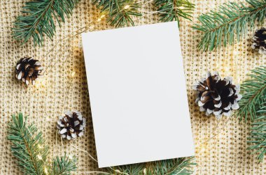 Noel tebrik kartı modeli çelenk ışıkları ve köknar ağacı dalları ile örülmüş arka plan, üst görünüm