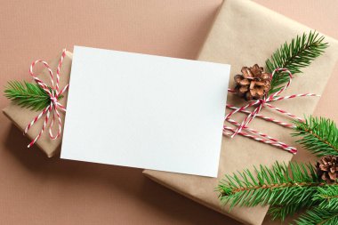 Noel ya da Yeni Yıl tebrik kartı maketi dekore edilmiş hediye kutuları ve konili köknar ağacı dalları