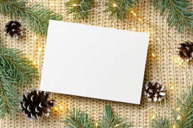 Noel ya da Yeni Yıl tebrik kartı modeli çelenk ışıkları ve örülmüş arka planda koni olan köknar ağacı dalları