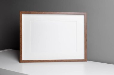 Landscape wooden frame mockup for artwork, photo and print presentation over grey wall.