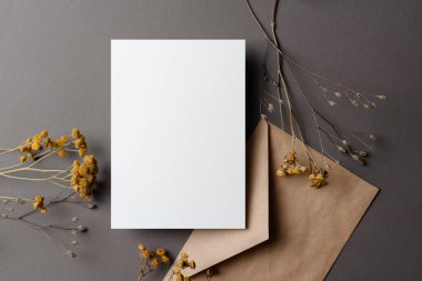 Invitation or greeting card mockup with dry flowers twigs and envelope