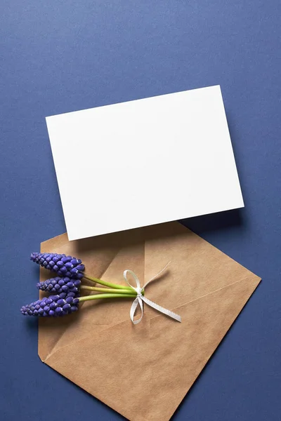 Invitation or greeting card mockup with envelope and spring blue muscari flowers — Stock fotografie