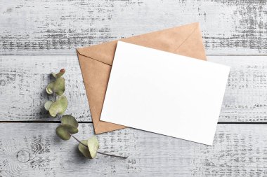 Ahşap zemin üzerinde kuru okaliptüs dalı olan tebrik ya da davet kartı modeli