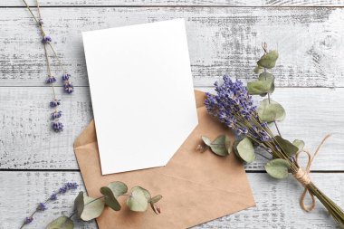 Davetiye ya da tebrik kartı modeli lavanta ve okaliptüs çiçekleri ahşap arka planda.