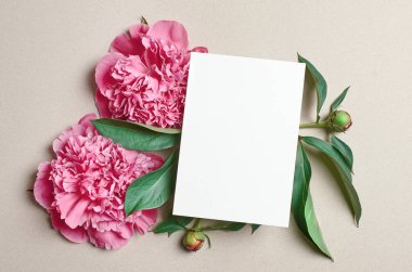 Kağıt arkaplanda pembe şakayık çiçekleri olan tebrik ya da davet kartı modeli, üst görünüm