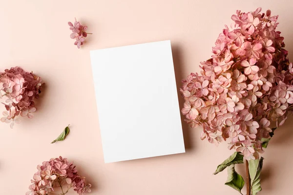 Invitation or greeting card mockup with hydrangea flowers. Blank card mockup on pink background.