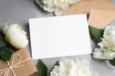 Tebrik kartı modeli hediye kutusu ve gri üzerine beyaz şakayık çiçekleri.