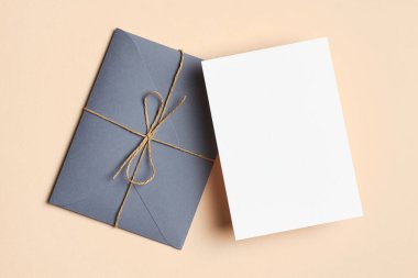 Bej kağıt arka planında zarf ile tebrik kartı durağan modelleme