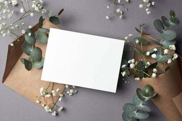 Wedding invitation or greeting card mockup with natural eucalyptus and gypsophila flowers