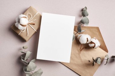 Hediye kutusu, doğal pamuk ve okaliptüs bitki süslemeleri ve üst görünümü olan tebrik ya da davet kartı maketi