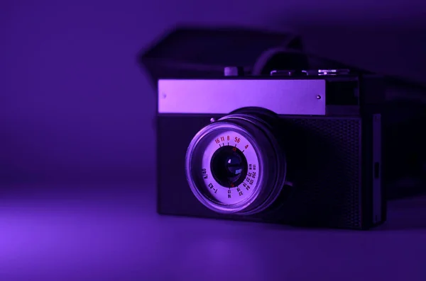Retro camera in purple neon light. Space for text. — Stock Photo, Image