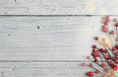 Kırmızı böğürtlenli ve yıldızlı hafif ahşap Noel arkaplanı. Bokeh, metin için boşluk.