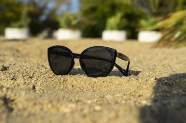 Parlak güneşten gelen bardaklar kumsaldaki çakıl taşlarında yatıyor..