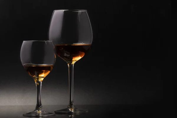 ワインと黒の背景に細い茎の上にガラスグラス — ストック写真