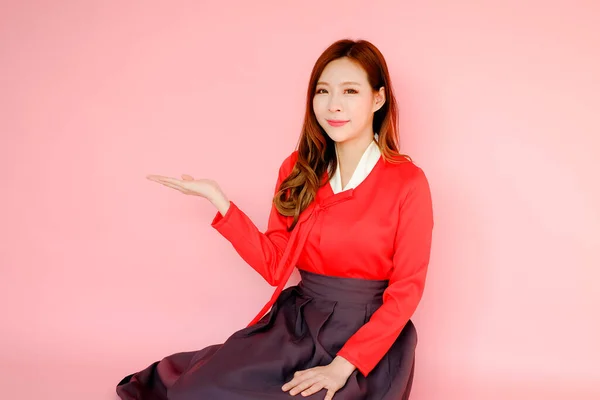 ピンクの背景に赤のモダンな韓服韓国スタイルを身に着けている肖像美しいアジアの女性 感情アクション — ストック写真