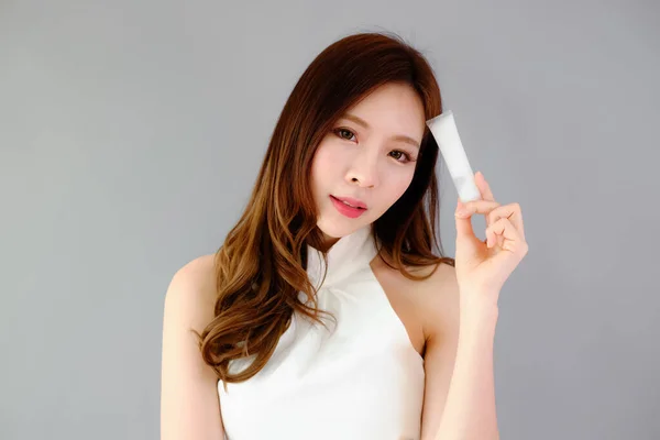 Portret Pięknej Azjatyckiej Kobiety Pokazujący Produkt Białą Tubą Kosmetyczną Plastikową — Zdjęcie stockowe