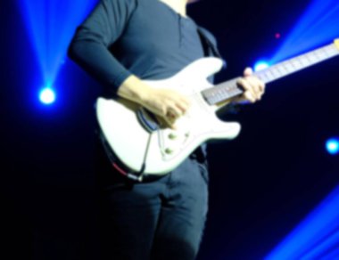 Bulanık rock adamı sahnede solo gitar çalıyor.