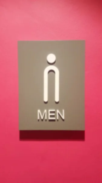 粉色背景上模糊的男厕标志 — 图库照片