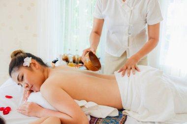 Genç Asyalı kadın spa masajında dinleniyor. Yatağa uzan.