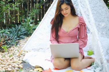 Bilgisayarla oynayan ya da çalışan Asyalı kadın