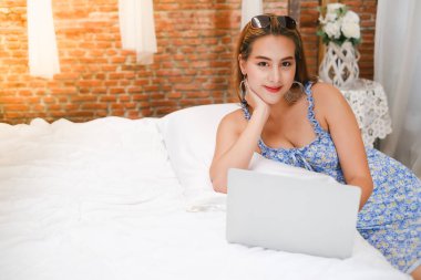 Bilgisayarla oynayan ya da çalışan Asyalı kadın