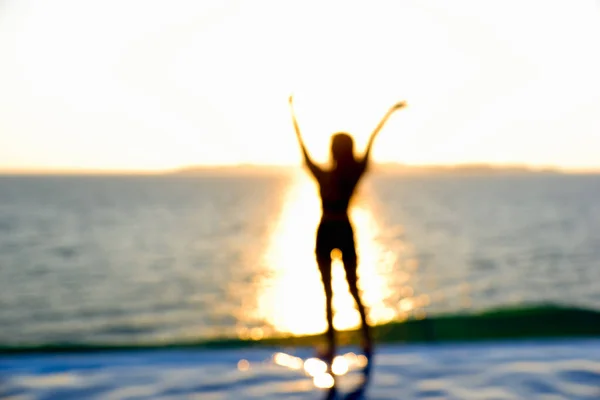 日出日落时在热带海滩手牵手快乐的女性的模糊轮廓 — 图库照片