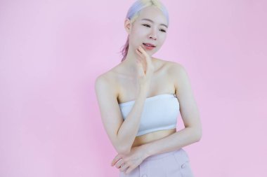 Güzel Asyalı kadın pozu pembe arka planda, duygu eylemi, güzellik konsepti