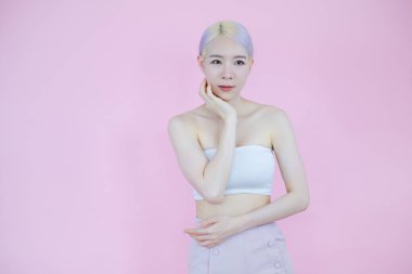 Güzel Asyalı kadın pozu pembe arka planda, duygu eylemi, güzellik konsepti