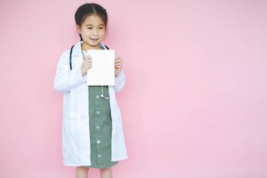 Pembe arka planda kırmızı kalp işareti olan güzel Asyalı kız çocuğu portresi.