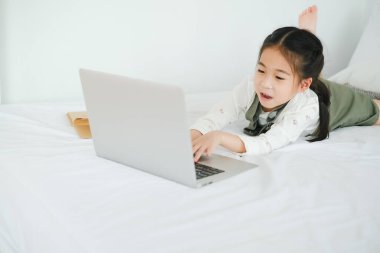 Asyalı küçük kız evde internetten öğreniyor.