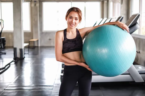 Asyalı kadın portresi spor kıyafetlerini spor salonunda, spor salonunda, güçlü kadın sporu ve kilo verme konseptinde giyiyor.