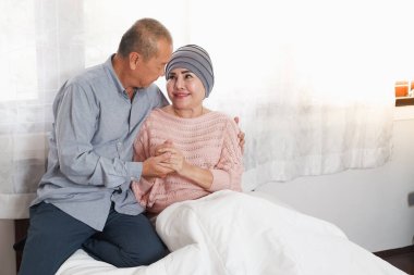Asyalı çift, son sınıf Asyalı kadın kemoterapi ve emeklilik adamı da yatakta teşvik edici.