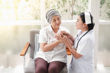 Asyalı kadın hemşireler evde yaşlı kadınlarla ilgilenirler.