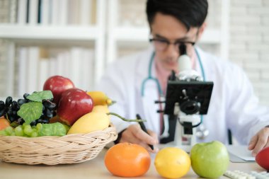 Asyalı beslenme uzmanı laboratuvarda yiyecek araştırması yapıyor.