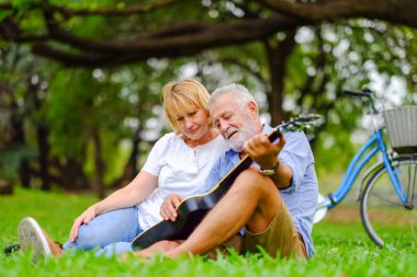 Portre mutlu iki Kafkasyalı parkta ve gitar çalıyor.