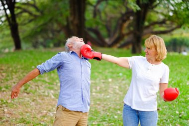 Kafkas kıdemli kadın ve yaşlı adam, parkta boks kırmızı eldivenleriyle kavga eden yaşlı bir çift.