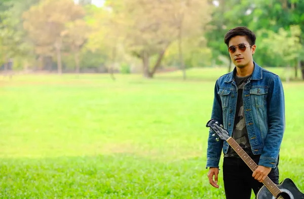 Parkta Gitar Tutan Asyalı Yakışıklı Adam Portresi — Stok fotoğraf