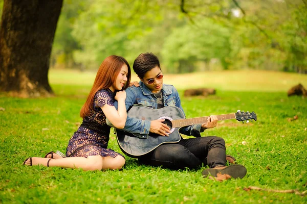 사랑하는 아시아인젊은 친구와 공원에서 생활을 기타를 — 스톡 사진