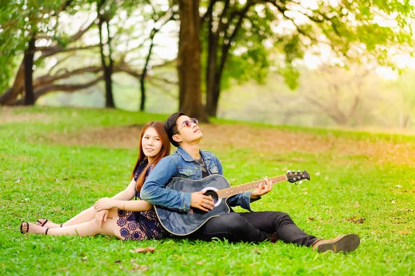 사랑하는 아시아인젊은 친구와 공원에서 생활을 기타를 — 스톡 사진