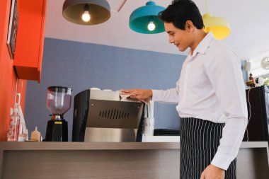 Asyalı garson kafe veya restoranda kahve servisi yapıyordu.